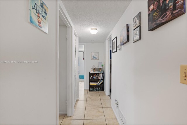 1145 N Shannon Unit 39, Indialantic, FL 32903 - hallway featuring a textured ceiling, light tile patterned floors, and baseboards