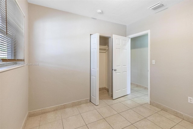 20740 NE 13th Ct, Miami, FL 33179 - unfurnished bedroom featuring light tile patterned flooring, baseboards, and a closet