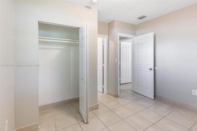 20740 NE 13th Ct, Miami, FL 33179 - unfurnished bedroom featuring a closet, light tile patterned flooring, and baseboards