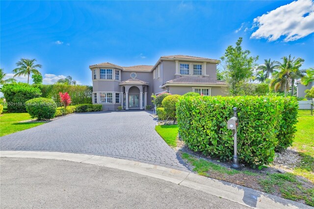 5081 NW 120th Ave, Coral Springs, FL 33076 - mediterranean / spanish-style house featuring stucco siding, decorative driveway, and a tile roof