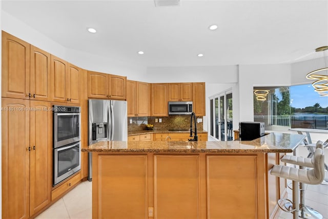 5081 NW 120th Ave, Coral Springs, FL 33076 - kitchen featuring appliances with stainless steel finishes, light stone countertops, backsplash, recessed lighting, and a breakfast bar