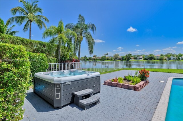 5081 NW 120th Ave, Coral Springs, FL 33076 - view of pool featuring a hot tub, a water view, a fenced backyard, and a patio