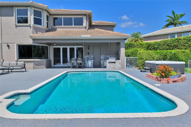 5081 NW 120th Ave, Coral Springs, FL 33076 - view of swimming pool featuring a hot tub, exterior kitchen, a patio area, and an outdoor living space