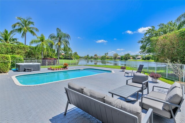 5081 NW 120th Ave, Coral Springs, FL 33076 - view of swimming pool featuring a patio, a water view, an outdoor hangout area, a hot tub, and view of scattered trees