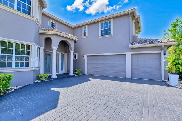 5081 NW 120th Ave, Coral Springs, FL 33076 - view of front facade with a garage, stucco siding, decorative driveway, and a tiled roof