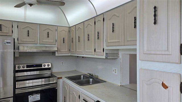 kitchen with stainless steel electric stove, fridge, a sink, wall chimney range hood, and light countertops