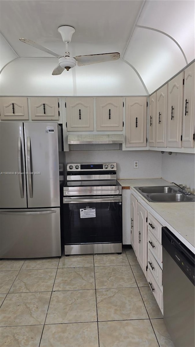 kitchen with appliances with stainless steel finishes, extractor fan, a sink, light countertops, and light tile patterned floors