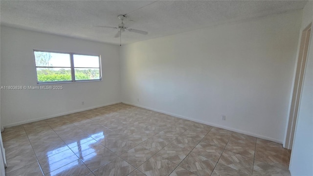 unfurnished room featuring a ceiling fan, baseboards, and a textured ceiling
