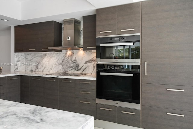 2127 Brickell Ave Unit 502, Miami, FL 33129 - kitchen featuring wall chimney range hood, black appliances, backsplash, dark brown cabinetry, and modern cabinets