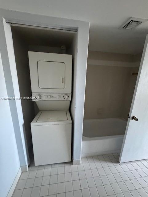 4724 NW 97th Ct Unit 87, Doral, FL 33178 - washroom with stacked washer / dryer, light tile patterned flooring, and baseboards