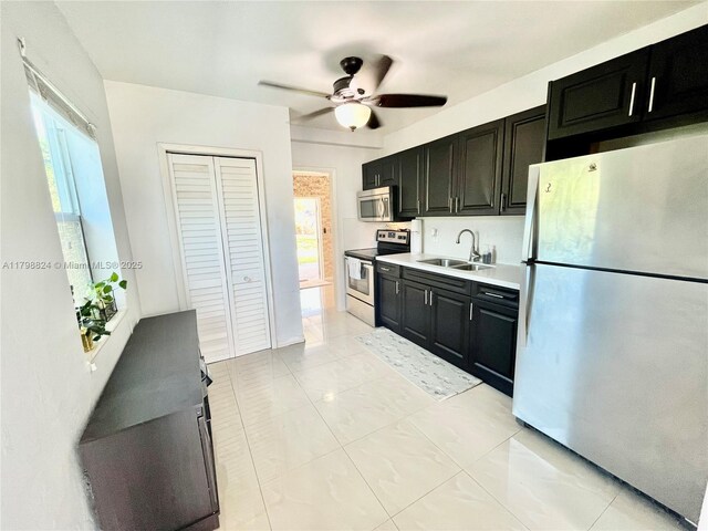 3135 SW 64th Ave, Miami, FL 33155 - kitchen featuring stainless steel appliances, a sink, dark cabinets, and plenty of natural light