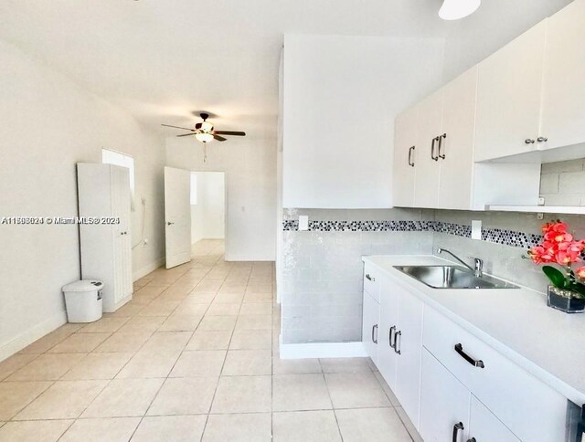 3135 SW 64th Ave, Miami, FL 33155 - kitchen with a sink, a ceiling fan, light tile patterned floors, light countertops, and white cabinets