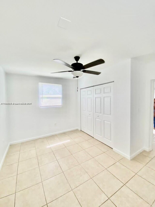 3135 SW 64th Ave, Miami, FL 33155 - unfurnished bedroom featuring light tile patterned flooring, baseboards, a closet, and a ceiling fan