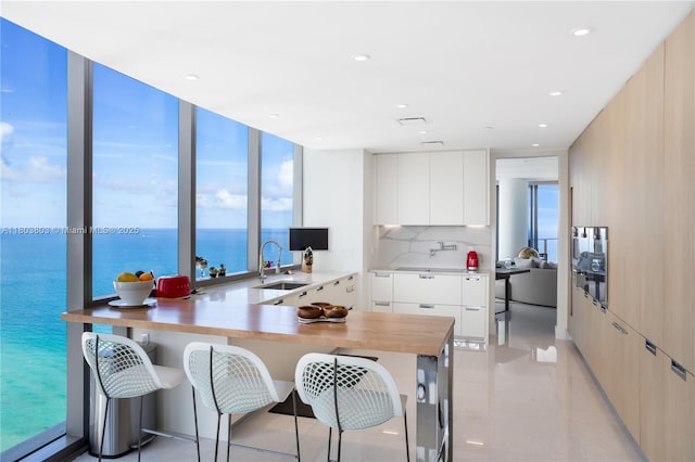 15701 Collins Ave Unit 3201, Sunny Isles Beach, FL 33160 - kitchen with modern cabinets, a sink, light countertops, a peninsula, and expansive windows