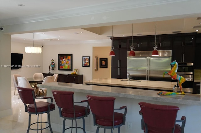 7740 SW 79th Ct, Miami, FL 33143 - kitchen featuring appliances with stainless steel finishes, a breakfast bar area, ornamental molding, a sink, and hanging light fixtures
