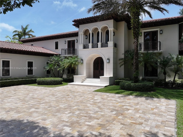 7740 SW 79th Ct, Miami, FL 33143 - mediterranean / spanish-style home featuring french doors, a balcony, stucco siding, a tile roof, and decorative driveway