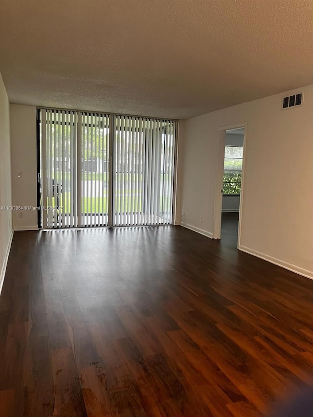 203 Lake Pointe Dr Unit 108, Oakland Park, FL 33309 - empty room featuring dark wood-style floors, baseboards, and a textured ceiling