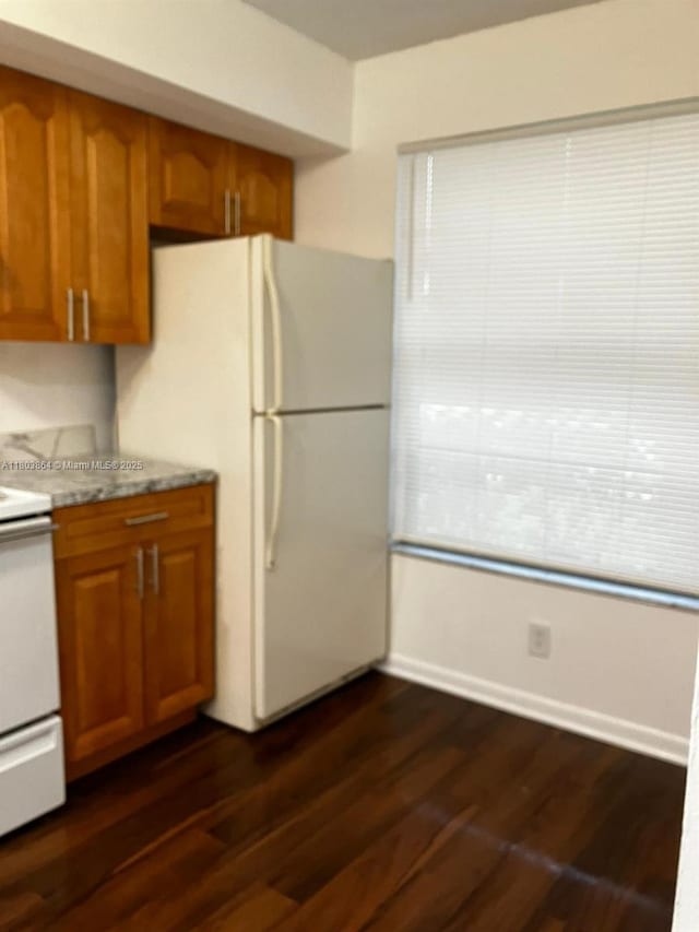 203 Lake Pointe Dr Unit 108, Oakland Park, FL 33309 - kitchen featuring brown cabinets, white appliances, and dark wood-style floors