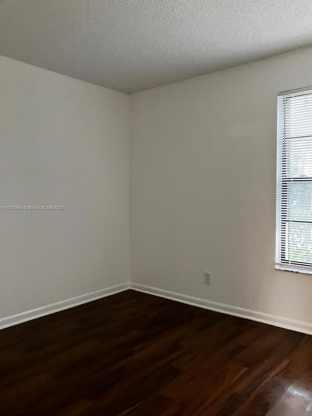 203 Lake Pointe Dr Unit 108, Oakland Park, FL 33309 - spare room with dark wood-style floors, baseboards, and a textured ceiling