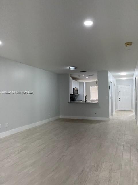 447 Lakeview Dr Unit 5, Weston, FL 33326 - unfurnished living room with baseboards, light wood-style floors, recessed lighting, and a sink
