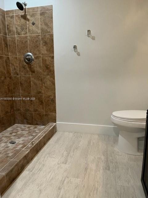 447 Lakeview Dr Unit 5, Weston, FL 33326 - bathroom with a tile shower, toilet, baseboards, and wood finished floors