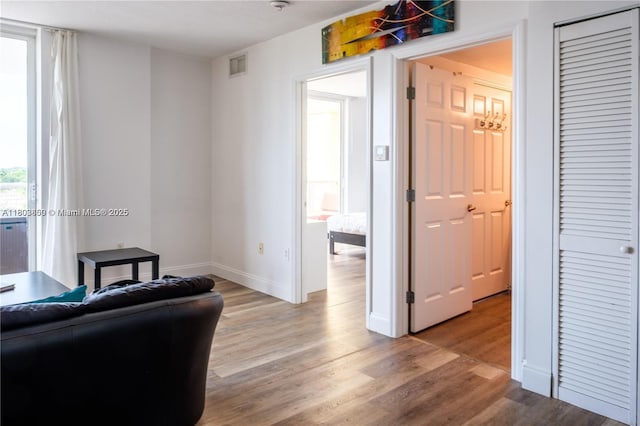 living area with light wood-type flooring and baseboards