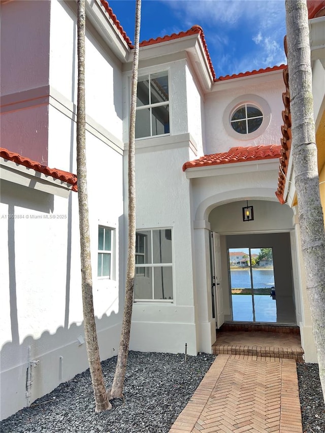 16247 SW 46th Ter, Miami, FL 33185 - view of exterior entry featuring a tile roof, stucco siding, and a water view