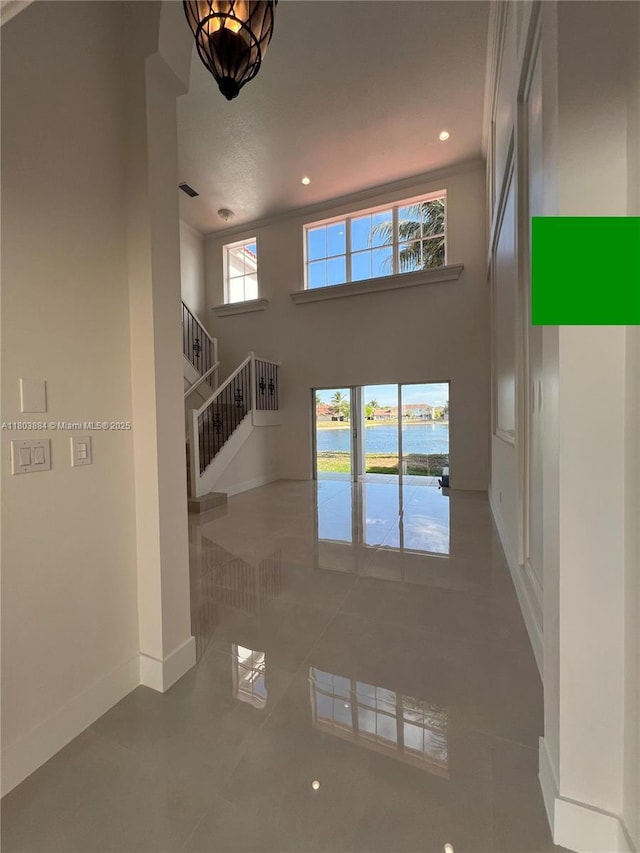 16247 SW 46th Ter, Miami, FL 33185 - unfurnished living room featuring stairs, baseboards, a high ceiling, recessed lighting, and a water view