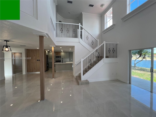 16247 SW 46th Ter, Miami, FL 33185 - staircase with a high ceiling, tile patterned floors, ornamental molding, and baseboards