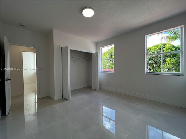 16247 SW 46th Ter, Miami, FL 33185 - unfurnished bedroom featuring baseboards, light tile patterned flooring, a closet, and a textured ceiling