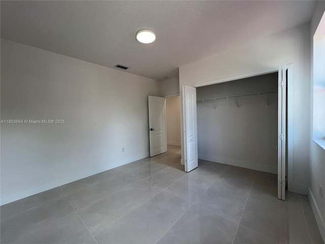 16247 SW 46th Ter, Miami, FL 33185 - unfurnished bedroom featuring light tile patterned floors, a closet, baseboards, and a textured ceiling