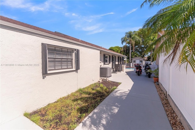 9813 SW 57th St, Cooper City, FL 33328 - view of side of home with stucco siding, cooling unit, and a patio area