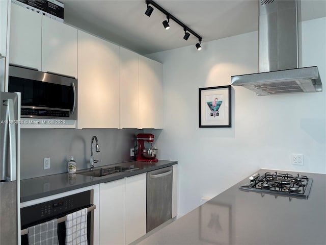 1618 Michigan Ave Unit 26, Miami Beach, FL 33139 - kitchen with stainless steel appliances, wall chimney exhaust hood, track lighting, dark countertops, and white cabinetry