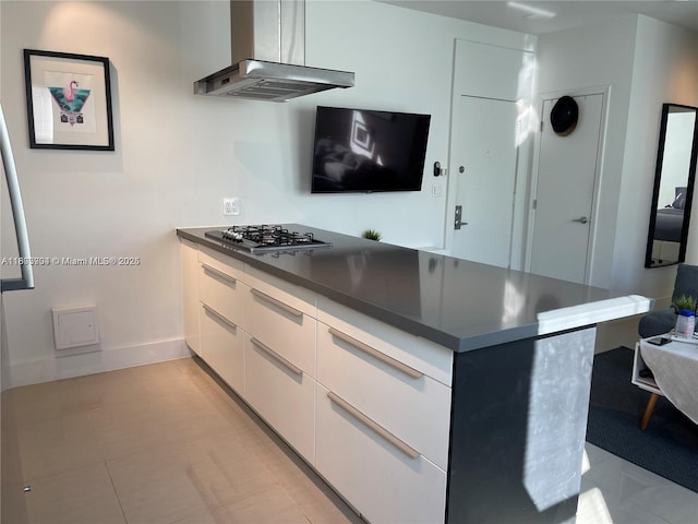 1618 Michigan Ave Unit 26, Miami Beach, FL 33139 - kitchen featuring stainless steel gas stovetop, island range hood, white cabinets, modern cabinets, and dark countertops