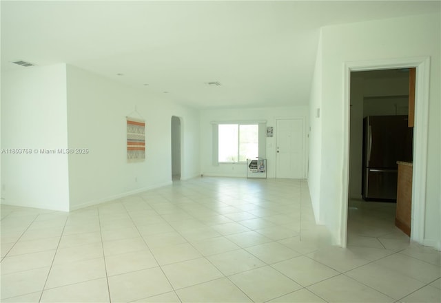 8851 Byron Ave, Surfside, FL 33154 - empty room featuring arched walkways and light tile patterned floors