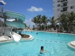 8851 Byron Ave, Surfside, FL 33154 - community pool featuring a water slide