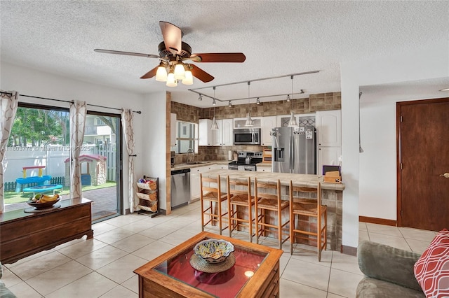 16465 NE 26th Ave Unit 18, North Miami Beach, FL 33160 - living room featuring track lighting, a ceiling fan, a textured ceiling, and light tile patterned floors