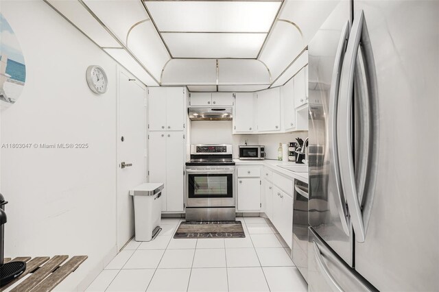 300 Bayview Dr Unit 812, Sunny Isles Beach, FL 33160 - kitchen featuring stainless steel appliances, under cabinet range hood, light countertops, white cabinetry, and light tile patterned floors