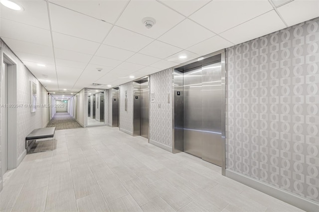 300 Bayview Dr Unit 812, Sunny Isles Beach, FL 33160 - hallway with elevator, recessed lighting, wallpapered walls, a paneled ceiling, and baseboards