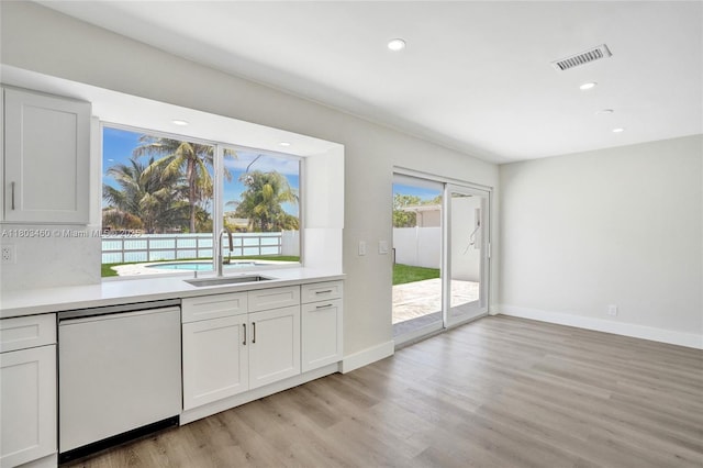 2021 N 53rd Ave, Hollywood, FL 33021 - kitchen with white dishwasher, a sink, light wood-style floors, light countertops, and recessed lighting