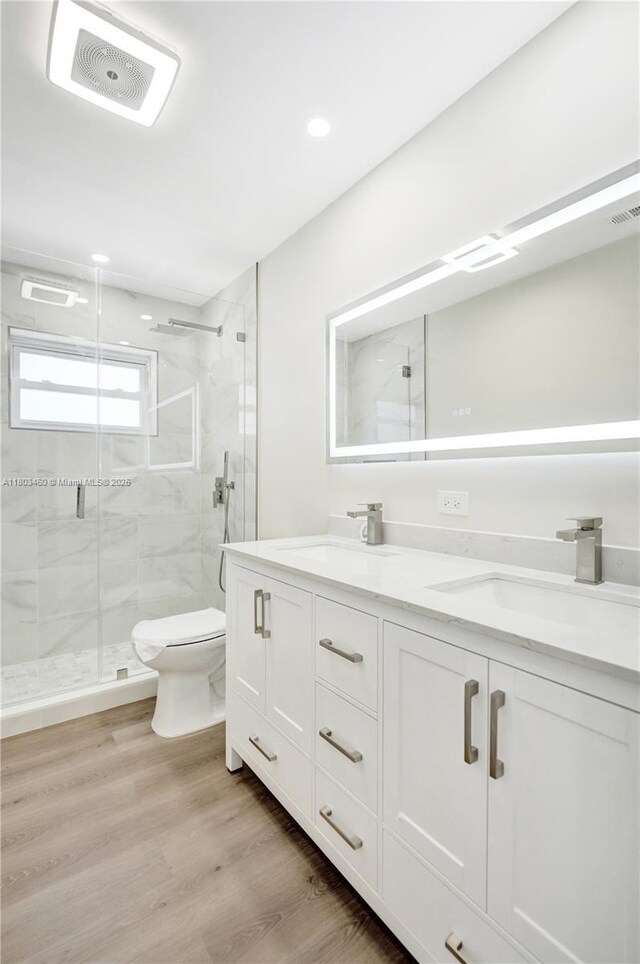 2021 N 53rd Ave, Hollywood, FL 33021 - bathroom featuring a marble finish shower, toilet, double vanity, wood finished floors, and recessed lighting