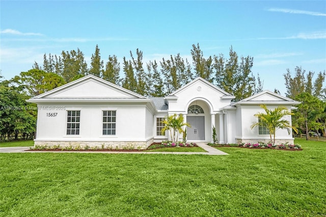 view of front facade with a front lawn and stucco siding