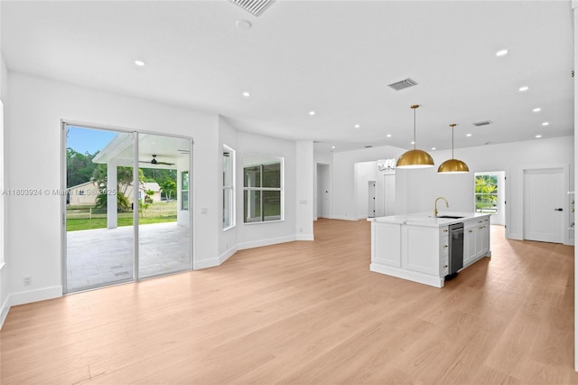 kitchen featuring a sink, dishwasher, recessed lighting, light wood-style flooring, and light countertops