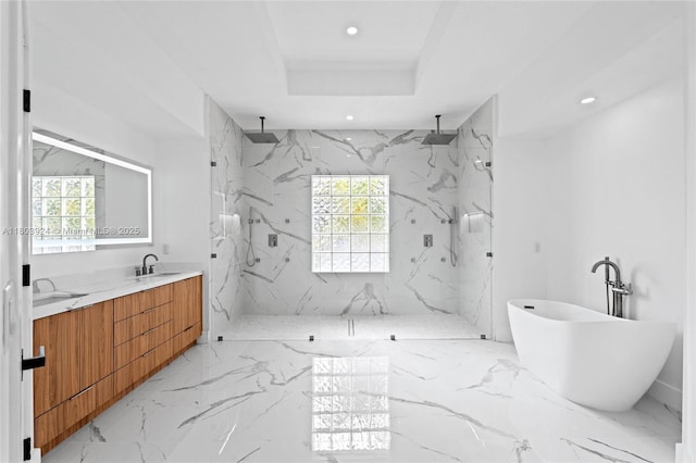 bathroom with marble tiled flooring, a marble finish shower, recessed lighting, double vanity, and a freestanding tub