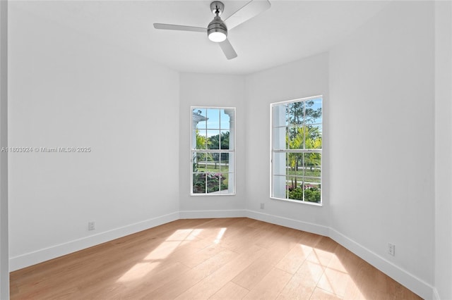 spare room with light wood-type flooring, baseboards, and a ceiling fan