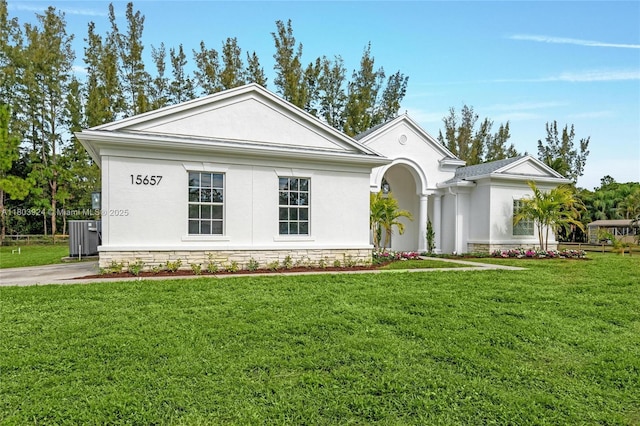 neoclassical / greek revival house with stucco siding, a front lawn, and central air condition unit