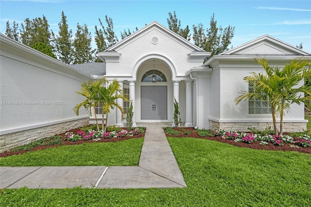 view of front facade with a front yard and stucco siding