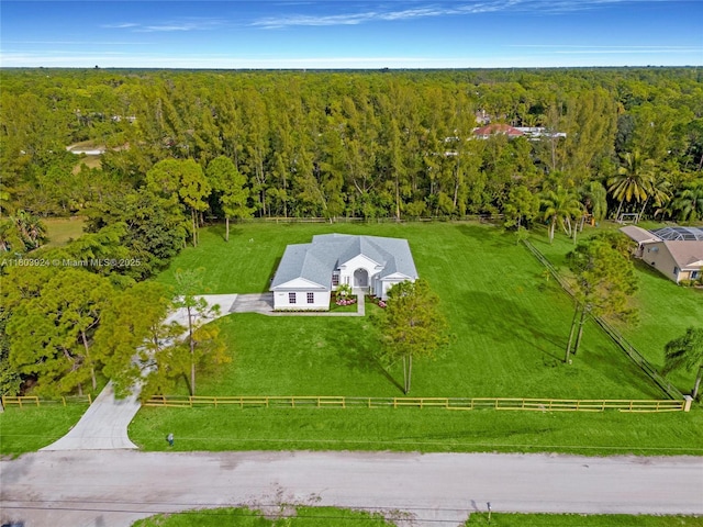 aerial view of property and surrounding area featuring a heavily wooded area