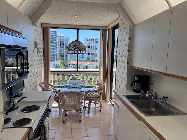 1000 Island Blvd Unit 1508, Aventura, FL 33160 - kitchen featuring a sink, light countertops, wallpapered walls, electric stove, and white cabinets