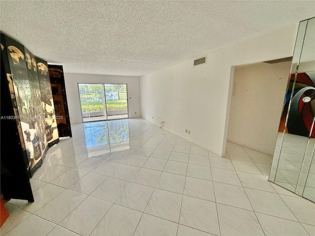 2305 Lucaya Ln Unit H1, Coconut Creek, FL 33066 - spare room with a textured ceiling and light tile patterned flooring